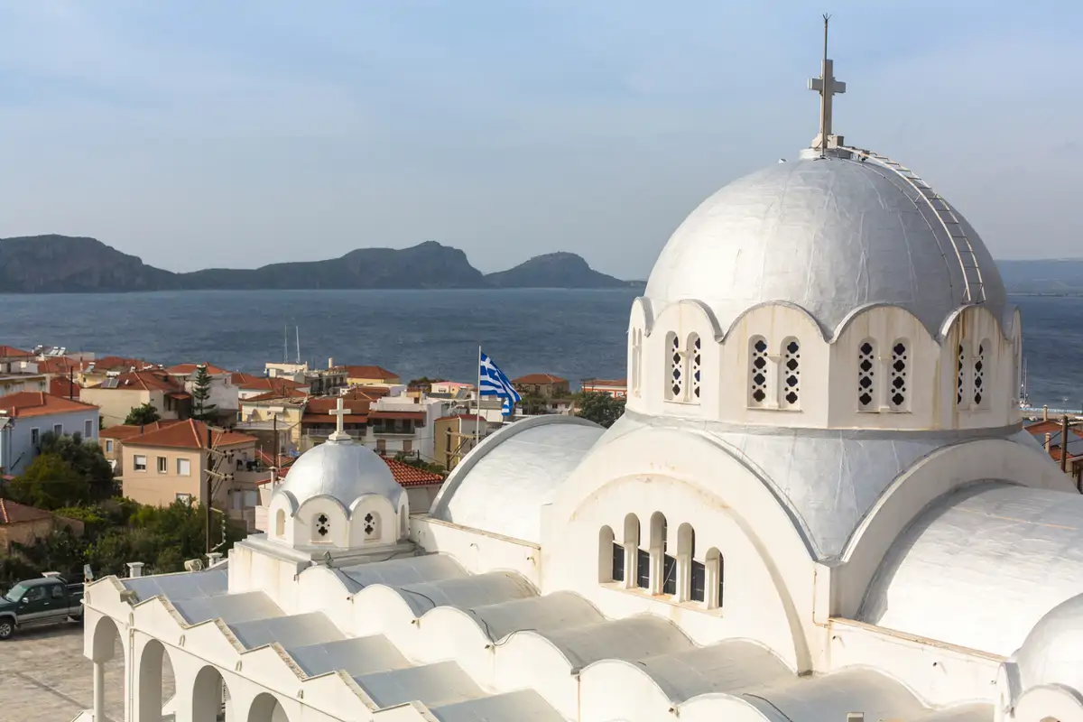 Una iglesia despunta con la ciudad de Pilos y el mar al fondo 